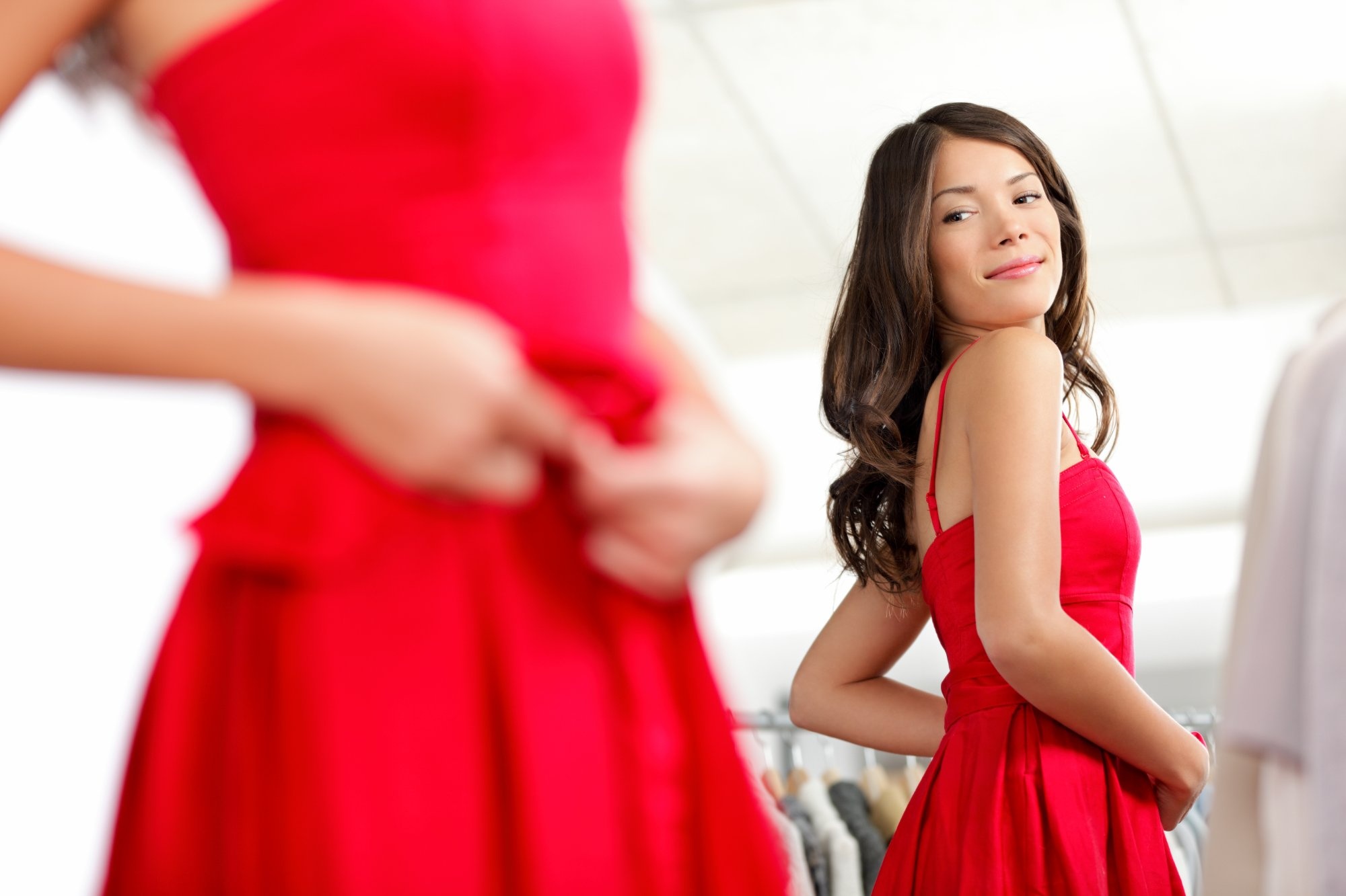 Woman trying on a red dress in mirror